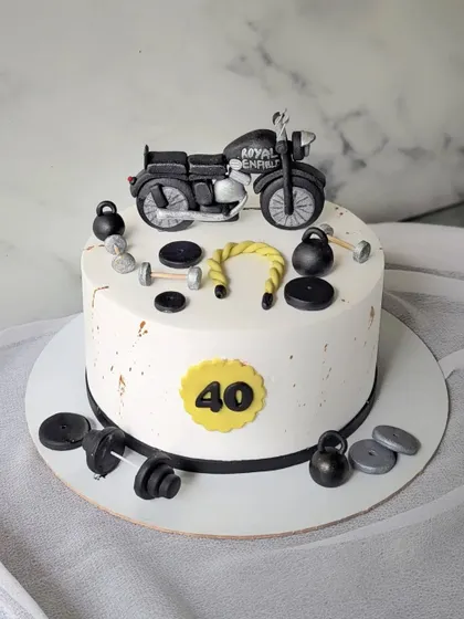 A cake for a fitness freak and Royal Enfield lover. This 40th birthday cake is decorated with a Bullet motorcycle, kettlebells, and dumbbells.