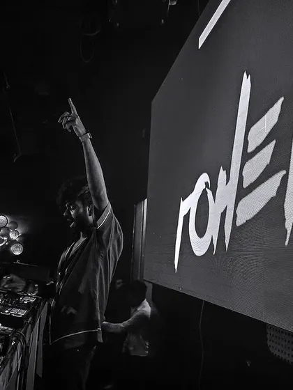 My name on the big screen at a club in Pune. This black and white shot captures the intensity of a live performance, where the focus is purely on the music and the artist.