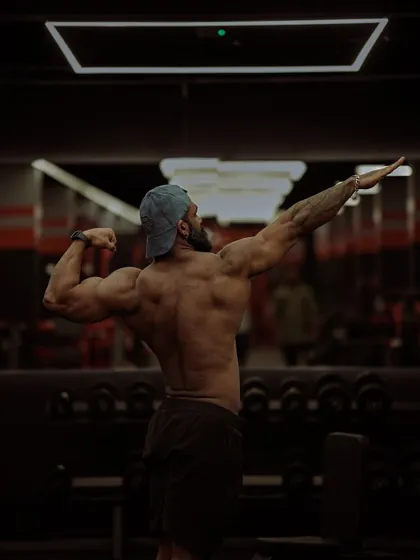 The back view of the same aesthetic pose, showing the detail and musculature of the posterior chain. A complete physique is developed from all angles.