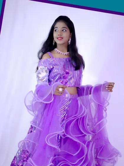 A young model in a sparkling purple ruffled lehenga, perfect for parties, weddings, or a fashion shoot.