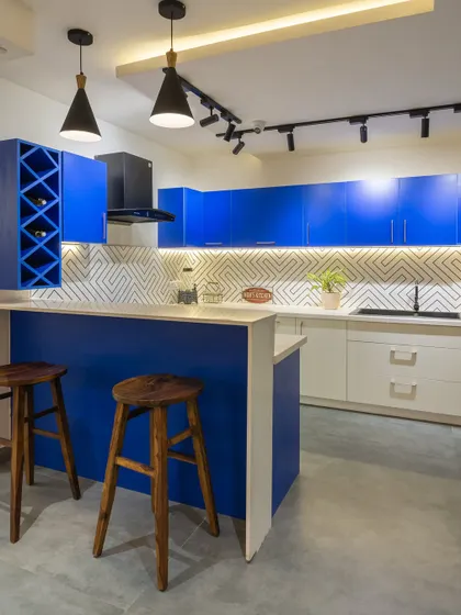 A bold and modern kitchen from our Gurugram Experience Centre, featuring a striking combination of electric blue and white cabinets and a functional breakfast bar.