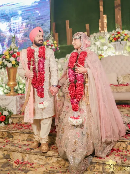 The couple walking down the steps after their ceremony, hand in hand.