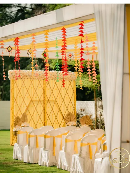 The outdoor Haldi setup, showing the guest seating and the beautifully decorated stage area.