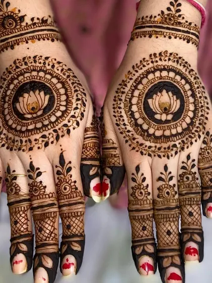 A striking mandala design with a lotus at its center, surrounded by intricate dot work. The bold, dark fingertips complete this festive look.