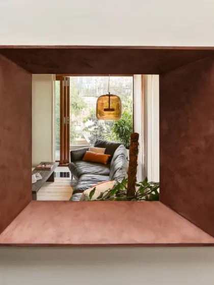 A deep, copper-toned portal in the Timber Edge project frames a view into the living room, creating a picture-like, layered spatial experience.