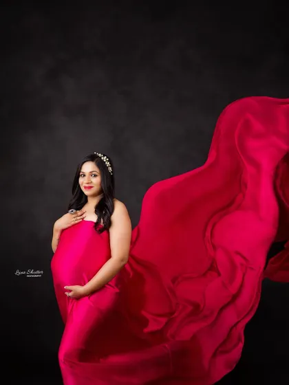 A dynamic fabric toss that creates a sense of movement and power. The vibrant pink gown looks absolutely stunning in motion against the dark backdrop.