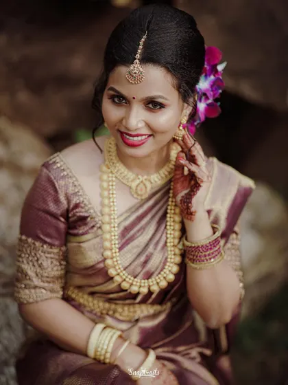 A classic portrait of a Hindu bride, showcasing her stunning gold jewelry and the rich color of her saree.