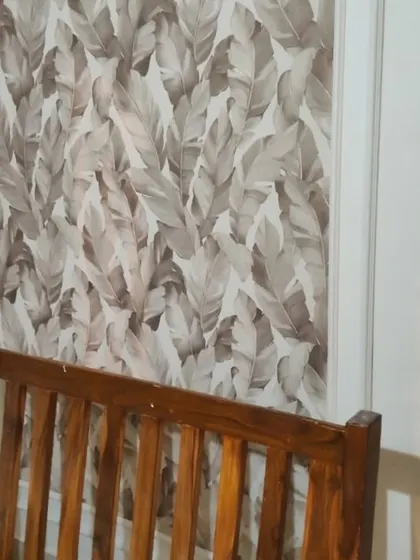 A close-up of a neutral-toned leaf pattern wallpaper installed within a wall panel. This technique adds texture and a subtle design element, perfect for a sophisticated living area.