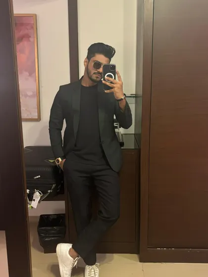 A quick mirror selfie before heading out for a New Year's Eve gig. A sharp, all-black suit for a big night.