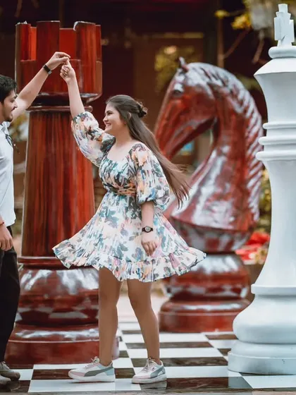 Another angle of the couple dancing on the giant chessboard, showing their fun and playful interaction.