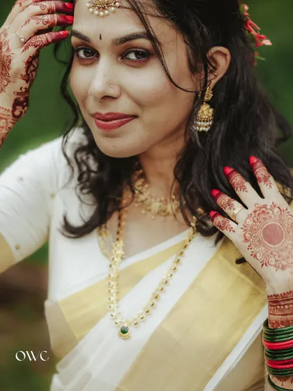 A beautiful close-up of a bride in a kasavu saree, highlighting her makeup and henna.