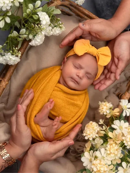 The parents' hands create a loving frame around their sleeping baby. A beautiful symbol of their protection and care.