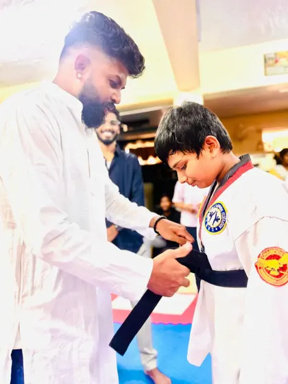 A young student receives his first degree black belt.