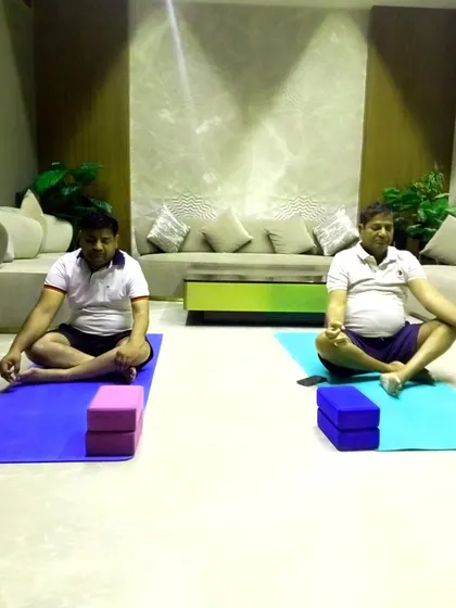Two employees practicing a seated meditative pose after an active asana session. I always include time for relaxation to ensure everyone leaves feeling refreshed.