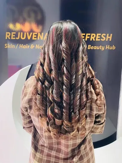 A beautiful combination of curls and color. The red-toned highlights are perfectly defined by the spiral curls, creating a truly eye-catching style.