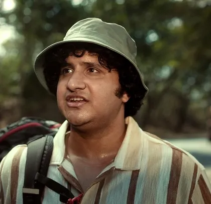 A close-up of one of the characters from the Nescafé ad. His bucket hat and striped shirt create a quirky, memorable look for his traveler persona.