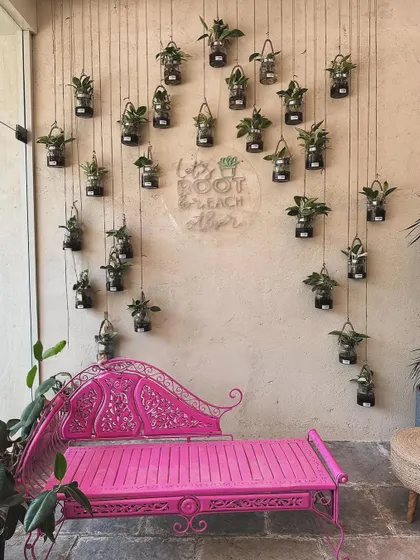 Our "Let's root for each other" wall is a favorite photo spot. The hanging glass planters and the vibrant pink bench create a beautiful and inspiring backdrop.