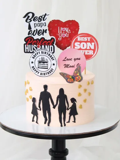A heartwarming cake celebrating a man who is a doting dad, a perfect husband, and the best son. This design uses silhouettes and custom toppers to convey a beautiful family story.