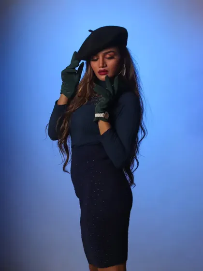 Playing with pose and accessories in the studio. The blue background adds a pop of color to this stylish, editorial portrait.