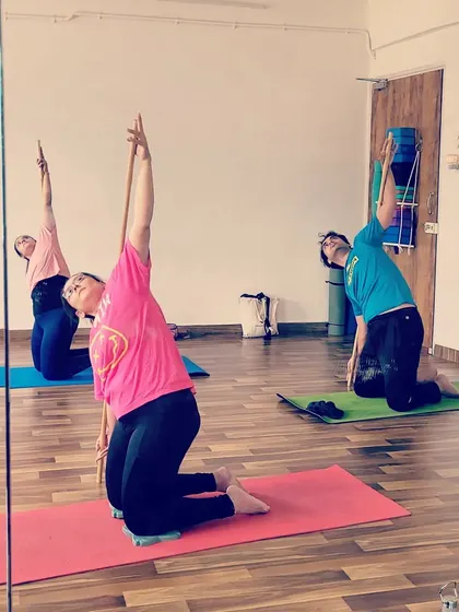 Students in my Stick Yoga workshop exploring side bends. The stick helps maintain posture and deepen the stretch along the side of the body.