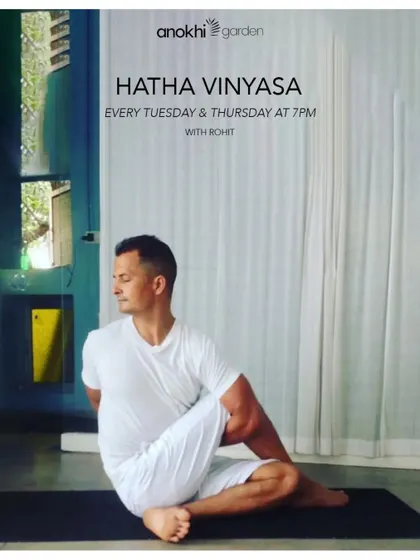 An instructor demonstrates a seated spinal twist in our Hatha Vinyasa class. This pose is excellent for improving spinal mobility and aiding digestion, reflecting the holistic benefits of our practices.