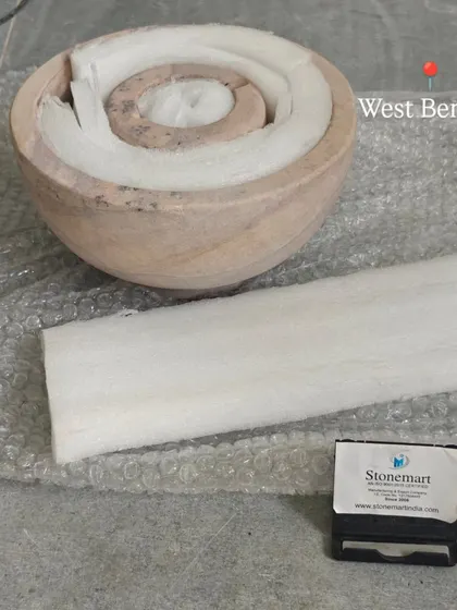 The components of a small tabletop fountain are carefully nested with foam padding before being placed in their shipping box.