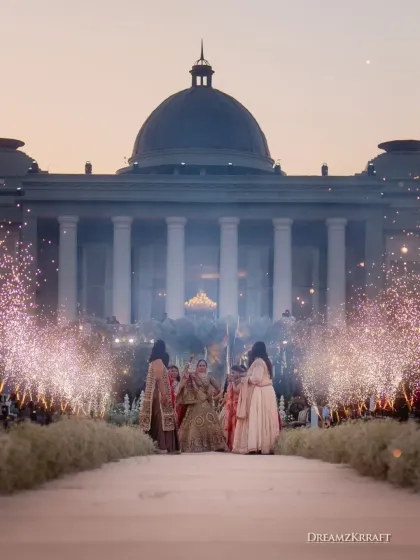 The bride's grand entrance for the varmala, perfectly framed by the palace architecture and sparkling cold pyros. We coordinate every element, from live music to special effects, to make these key moments truly cinematic.