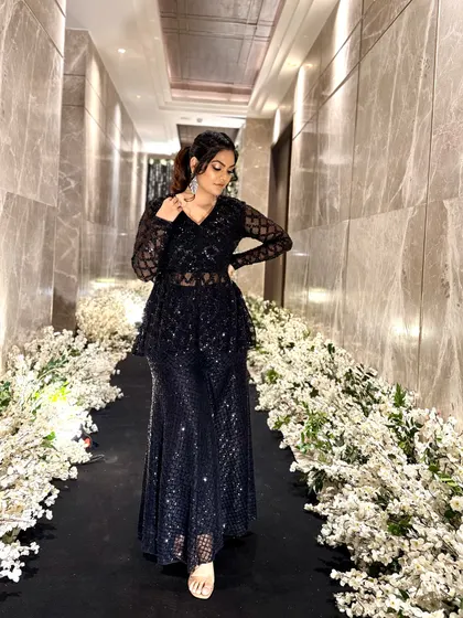 A full-length view of the sparkling black ethnic co-ord set. The sheer sleeves and detailed embroidery make it a sophisticated choice for any formal event.