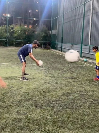 A coach demonstrates a throw-in to a young player. We cover all the rules and techniques of the game in our sessions.