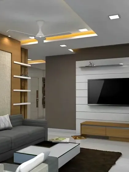 This living room design features a neutral color palette with a comfortable grey sofa and a simple TV unit. A large bas-relief artwork adds a unique textural element to the space.
