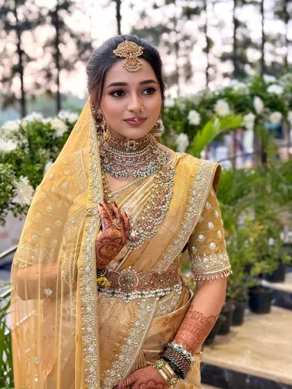 The complete look for Nischaya, showcasing the harmony between her stunning attire, heavy temple jewelry, and the elegant makeup.