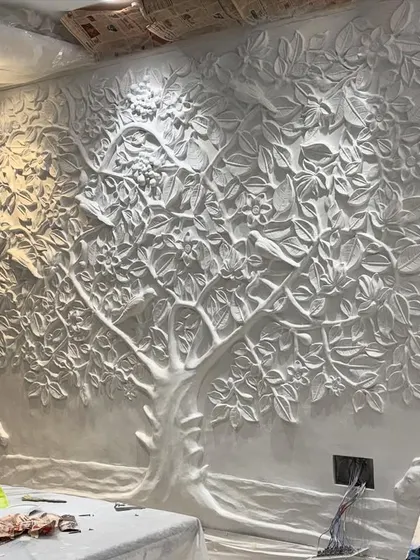 The raw, unpainted fiber sculpture of the Tree of Life, installed on the wall. This shows the foundational form before the artistic painting process begins.