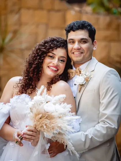 A joyful portrait of the happy couple. Her natural curls and his bright smile are a perfect match.