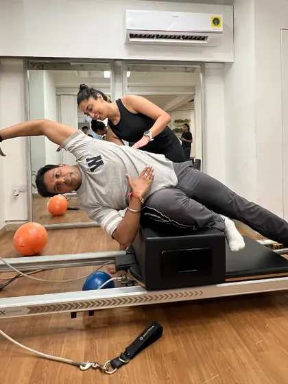 Congratulations to our newest instructor graduates. Here, a trainer-in-training gets hands-on experience correcting form on the reformer.