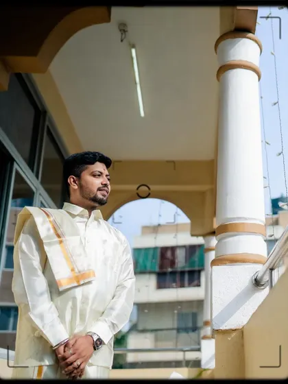 A portrait of the groom looking out from a balcony.