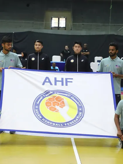 Officials hold the Asian Handball Federation (AHF) flag at the start of the tournament. We work closely with international sports federations to execute events flawlessly.