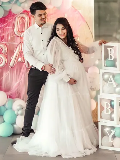 This white flare gown is perfect for a baby shower or an angelic maternity shoot. It features a sequined bodice and dramatic long balloon sleeves for a touch of whimsy.