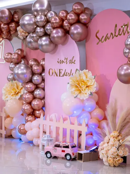 A "ONEderful" princess-themed first birthday in shades of pink and rose gold. The setup includes a mini pink car, pampas grass arrangements, and a custom backdrop for a truly royal celebration.