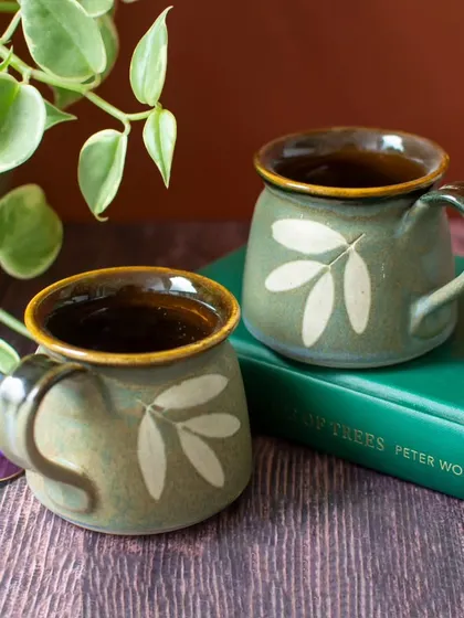 Another look at the green Lantana teacups, nestled amongst books and plants. Their earthy tones and leaf motif bring a sense of calm and connection to nature, perfect for a mindful break.
