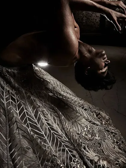 A dramatic pose from the Shantanu & Nikhil Summer 2022 campaign. The choreography aimed to create sculptural shapes with the body and fabric, resulting in visually arresting images.