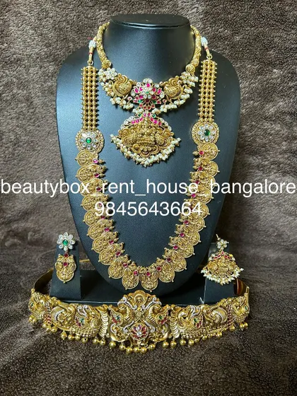 A kasu haram set with a unique temple pendant, paired with a matching choker and a kemp stone vaddanam.