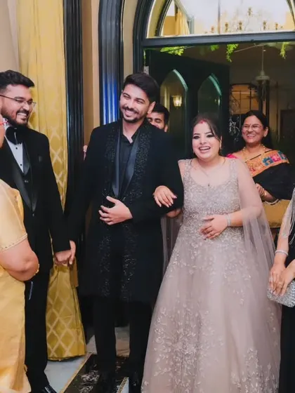 The couple being greeted by their family as they enter the reception hall, a warm and welcoming moment.