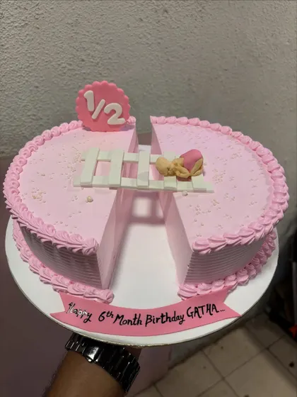 A creative half-birthday cake, designed as two semi-circles to represent the "1/2" milestone. It's a lovely way to celebrate six months of joy.