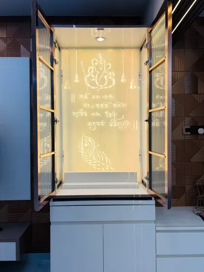 The mandir doors opened to reveal the sacred space, with a beautiful backlit panel featuring a Ganesha illustration and Sanskrit shlokas.