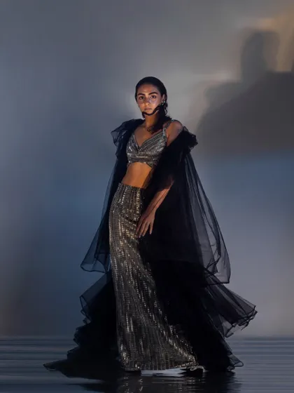 A full-length view of the wet hair look, complementing the flowing, sea-inspired garments.