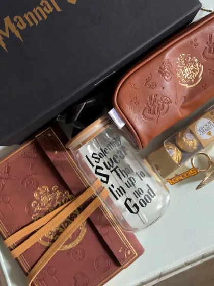 The complete Harry Potter "Wizarding World Hamper," featuring a personalized box, a "Marauder's Map" style journal, a "Seeker" keychain, and a themed glass tumbler.