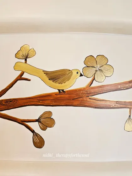A close-up view of one of the painted birds, highlighting the delicate brushwork and the metallic sheen of the golden flowers.