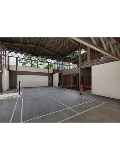 The indoor badminton court, designed with high ceilings and clerestory windows that bring in natural light without glare. The space is visually connected to the rest of the campus, reinforcing the theme of interconnectedness.