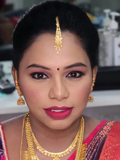 A classic baby shower makeup look. This features a flawless base, beautifully defined eyes, and a bold lip, paired with traditional gold jewelry for a timeless and elegant appearance.