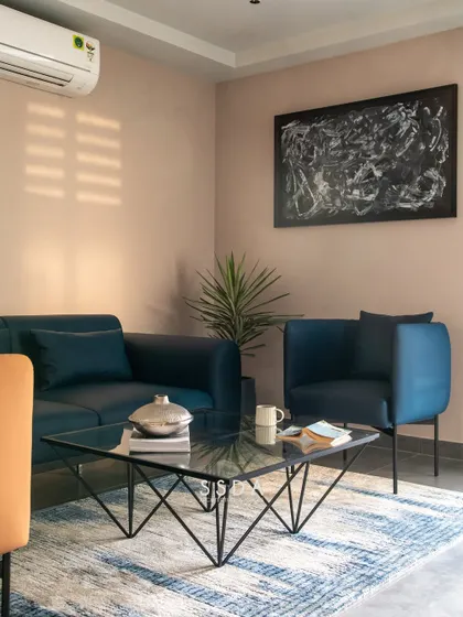 The waiting area in our studio, with a comfortable blue sofa and armchairs. The space is designed to be welcoming and reflective of our modern, layered style.